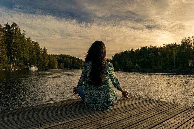 Person meditating by the water